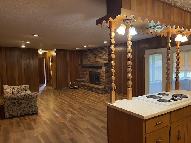 641 N Claud Ave, Bolivar, MO 65613 - kitchen with a textured ceiling, wood walls, light countertops, white electric stovetop, and open floor plan