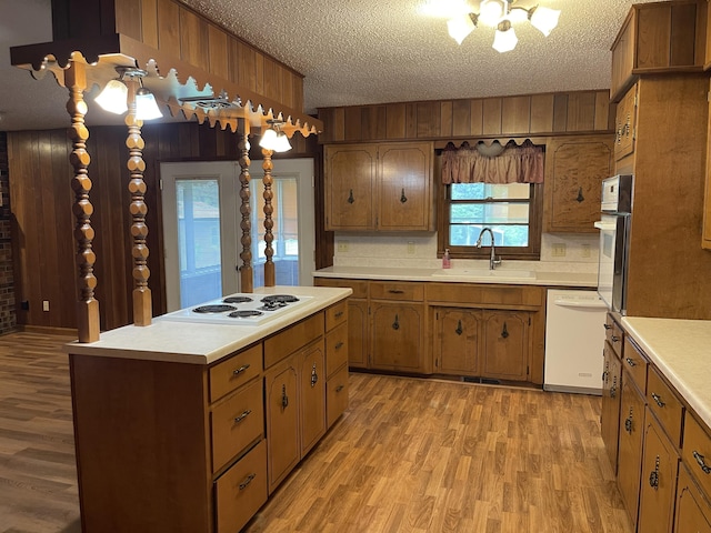 641 N Claud Ave, Bolivar, MO 65613 - kitchen with white appliances, light wood-style floors, light countertops, a sink, and wood walls