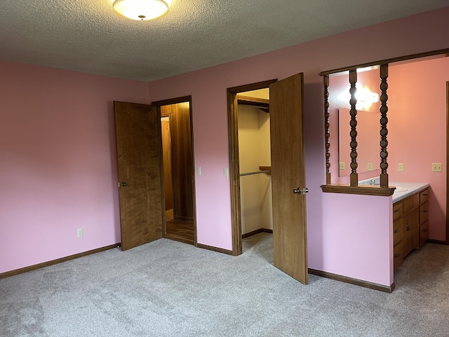 641 N Claud Ave, Bolivar, MO 65613 - unfurnished bedroom featuring carpet floors, a textured ceiling, a spacious closet, a closet, and baseboards