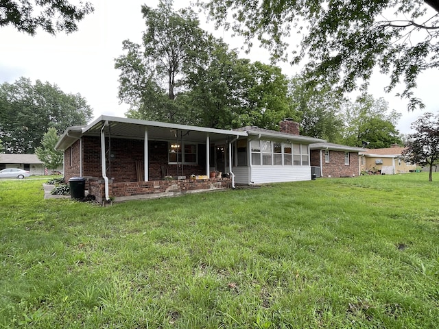641 N Claud Ave, Bolivar, MO 65613 - back of house with a chimney, a yard, a sunroom, and brick siding