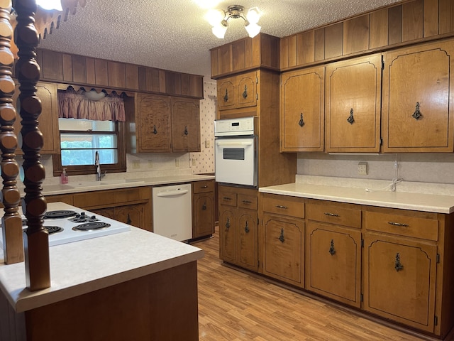 641 N Claud Ave, Bolivar, MO 65613 - kitchen featuring white appliances, a sink, brown cabinets, light countertops, and a textured ceiling