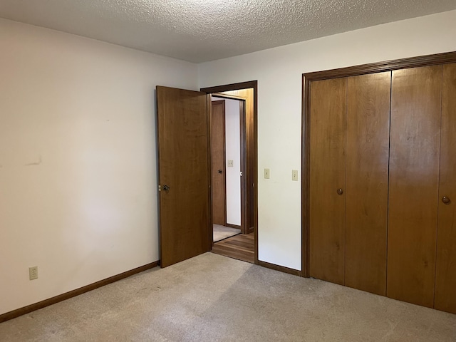 641 N Claud Ave, Bolivar, MO 65613 - unfurnished bedroom with light carpet, a closet, baseboards, and a textured ceiling