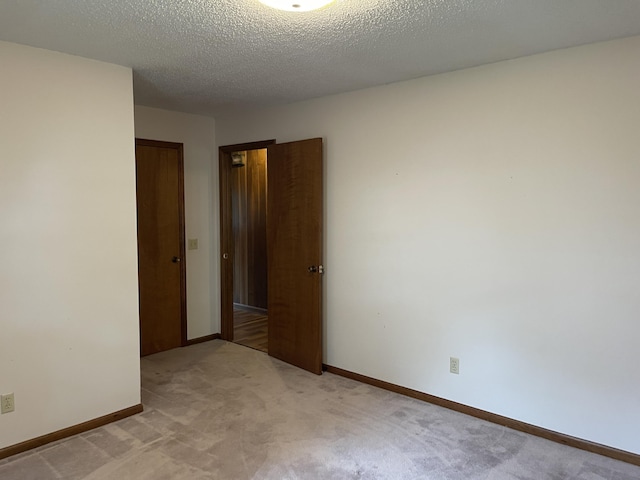 641 N Claud Ave, Bolivar, MO 65613 - empty room featuring light colored carpet, baseboards, and a textured ceiling