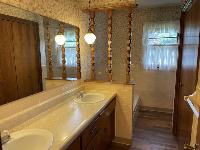 641 N Claud Ave, Bolivar, MO 65613 - full bathroom featuring wallpapered walls, double vanity, wood finished floors, a bath, and a wainscoted wall