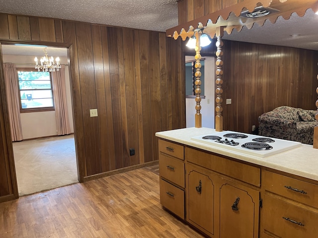 641 N Claud Ave, Bolivar, MO 65613 - kitchen featuring white electric cooktop, a chandelier, a textured ceiling, wooden walls, and light countertops