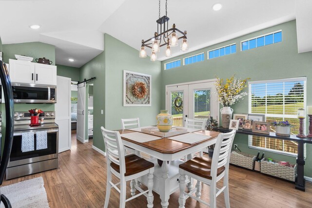 132 Nature Trail Ln, Noel, MO 64854 - dining space with a barn door, french doors, light wood-style floors, a chandelier, and high vaulted ceiling