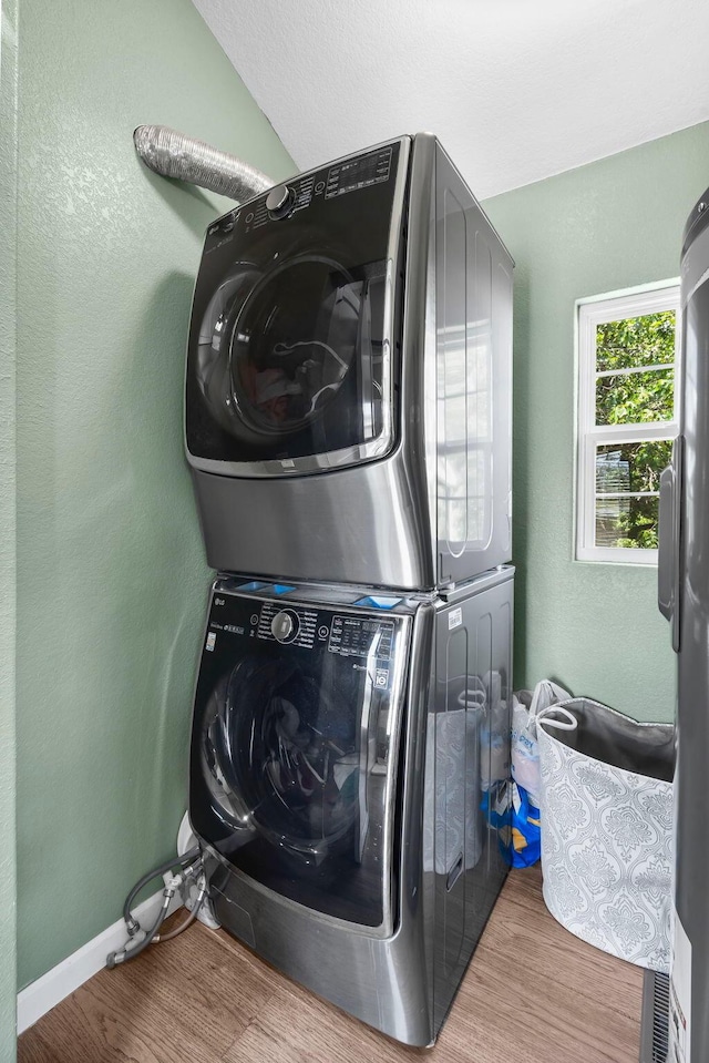 132 Nature Trail Ln, Noel, MO 64854 - laundry room featuring stacked washer / dryer, wood finished floors, a textured wall, and baseboards