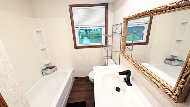9550 S 325th Rd, El Dorado Springs, MO 64744 - full bathroom featuring wood finished floors, toilet, vanity, baseboards, and tub / shower combination