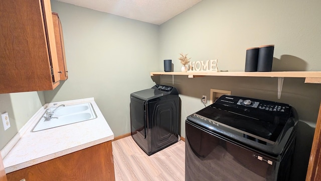 9550 S 325th Rd, El Dorado Springs, MO 64744 - laundry room with washing machine and clothes dryer, cabinet space, light wood finished floors, and baseboards