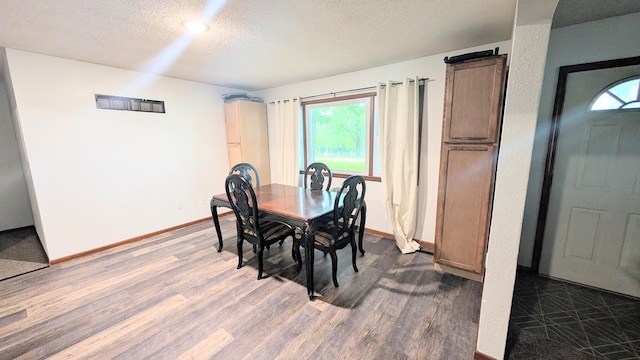 9550 S 325th Rd, El Dorado Springs, MO 64744 - dining area featuring dark wood-style floors, a textured ceiling, and baseboards