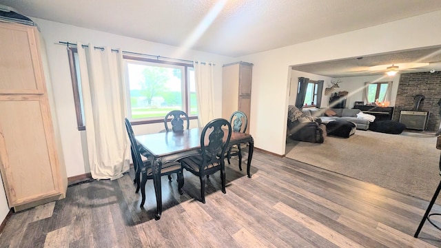 9550 S 325th Rd, El Dorado Springs, MO 64744 - dining area with wood finished floors, baseboards, healthy amount of natural light, and a wood stove