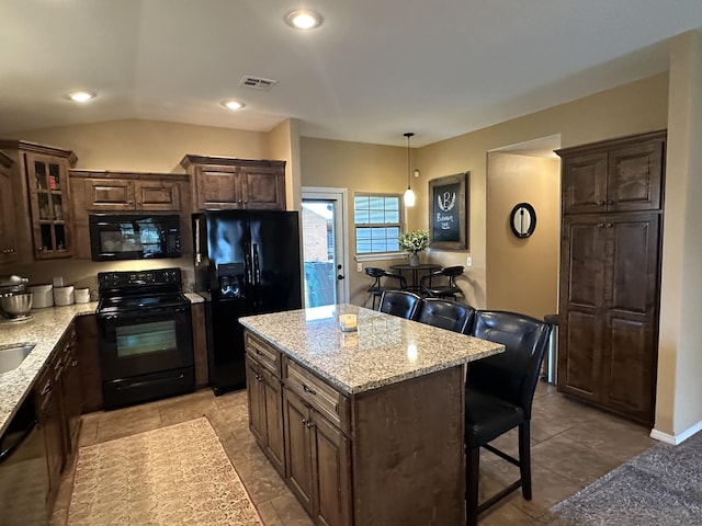 2818 E 16th St, Joplin, MO 64804 - kitchen with black appliances, dark brown cabinetry, a kitchen bar, and recessed lighting