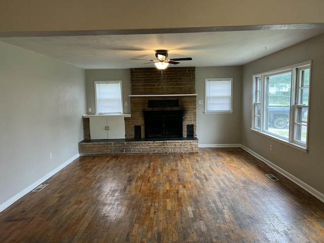 101 W Pennsylvania Ave, Mansfield, MO 65704 - unfurnished living room featuring wood-type flooring, a ceiling fan, baseboards, and a brick fireplace