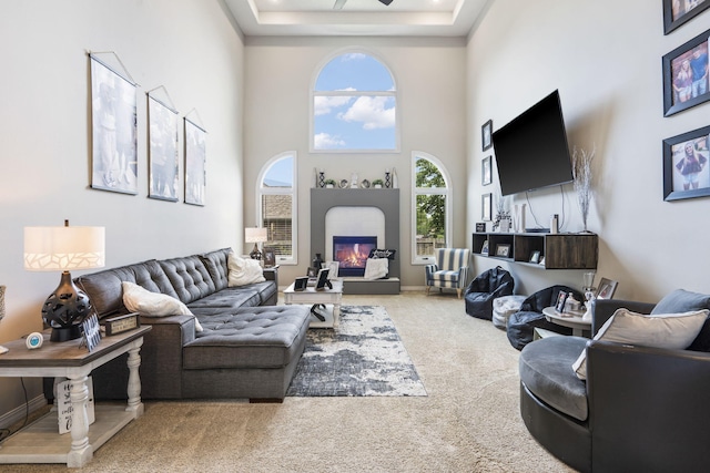 3909 W Eaglecrest St, Battlefield, MO 65619 - carpeted living room with a glass covered fireplace, a towering ceiling, and a raised ceiling