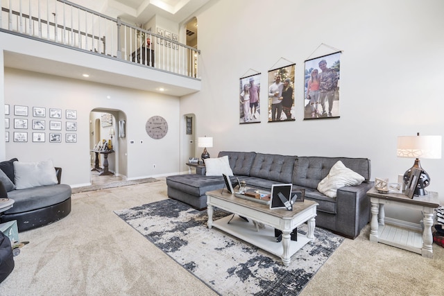 3909 W Eaglecrest St, Battlefield, MO 65619 - carpeted living area with arched walkways, a high ceiling, and baseboards