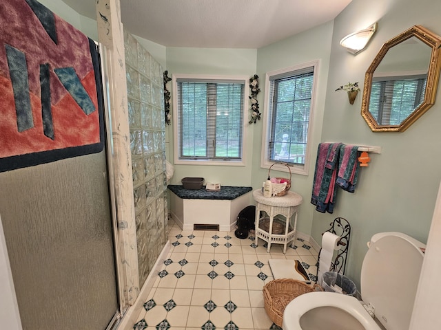 9726 County Road 8530, West Plains, MO 65775 - bathroom with toilet, tile patterned flooring, a stall shower, and baseboards
