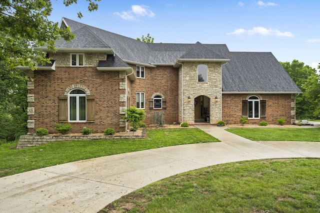95 Highland Ct, Strafford, MO 65757 - view of front facade with a front yard, a shingled roof, stone siding, and brick siding