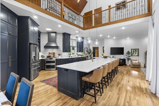 95 Highland Ct, Strafford, MO 65757 - kitchen featuring custom exhaust hood, stainless steel appliances, light wood-style floors, light countertops, and a high ceiling