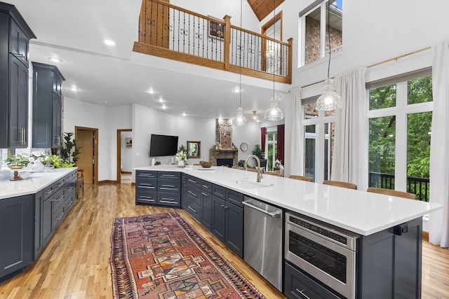 95 Highland Ct, Strafford, MO 65757 - kitchen featuring appliances with stainless steel finishes, a sink, open floor plan, light countertops, and a towering ceiling