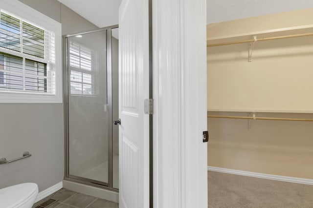 4972 E Cherry Cir, Springfield, MO 65809 - bathroom featuring a stall shower, a walk in closet, baseboards, and toilet