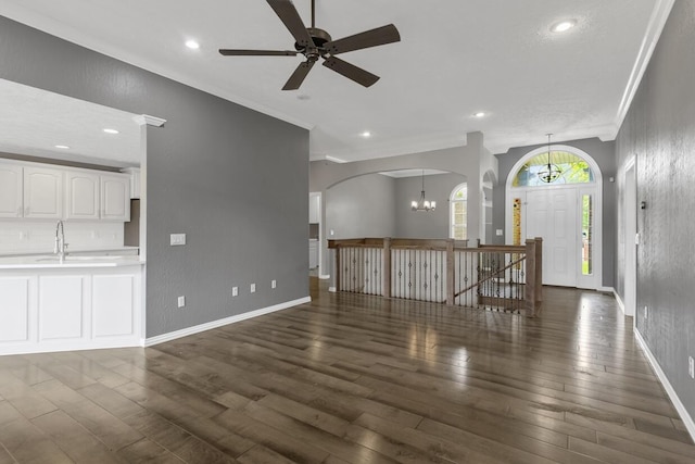 4972 E Cherry Cir, Springfield, MO 65809 - unfurnished living room featuring a chandelier, crown molding, dark wood-style floors, a ceiling fan, and baseboards