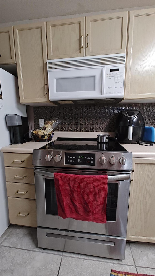 610 Abby Ln Par 61, Branson, MO 65616 - kitchen featuring stainless steel electric stove, white microwave, backsplash, and light tile patterned floors