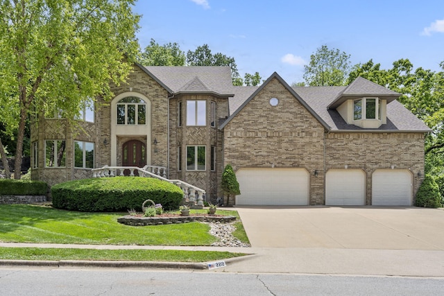 2212 E Nottingham St, Springfield, MO 65804 - view of front facade featuring driveway, a front lawn, brick siding, and roof with shingles