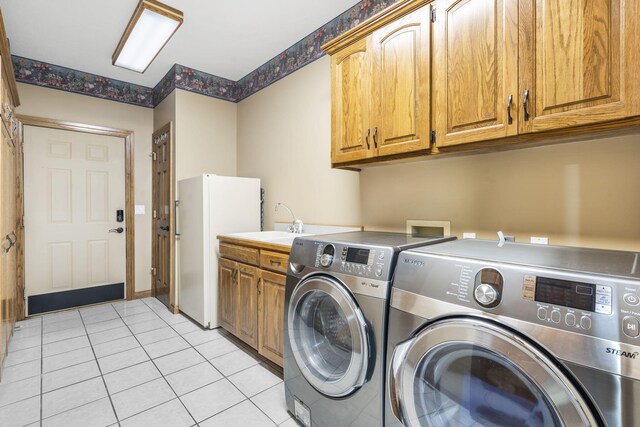 2212 E Nottingham St, Springfield, MO 65804 - laundry area featuring cabinet space, washing machine and clothes dryer, and light tile patterned flooring