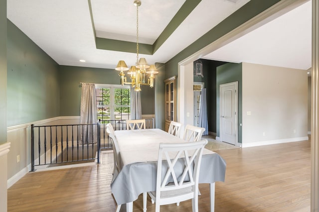 5072 E Hedgerow Dr, Springfield, MO 65802 - dining room with a chandelier, light wood-style floors, a tray ceiling, and baseboards