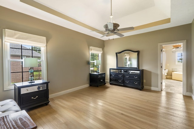 5072 E Hedgerow Dr, Springfield, MO 65802 - bedroom with light wood-type flooring, baseboards, a raised ceiling, and ensuite bathroom