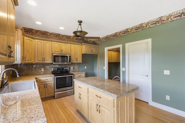5072 E Hedgerow Dr, Springfield, MO 65802 - kitchen featuring stainless steel appliances, a sink, tile countertops, light wood-style floors, and backsplash
