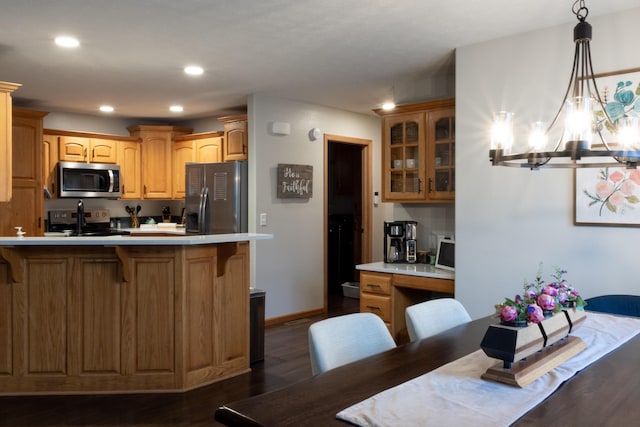 1585 S Mission Ave, Bolivar, MO 65613 - kitchen featuring appliances with stainless steel finishes, a kitchen bar, glass insert cabinets, a chandelier, and dark wood-style floors
