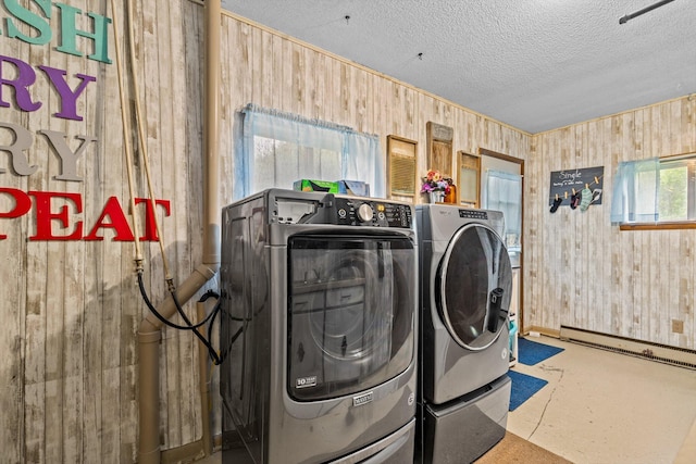 1650 Clouse Rd, Macomb, MO 65702 - laundry area featuring wood walls, a textured ceiling, washing machine and dryer, and a baseboard heating unit