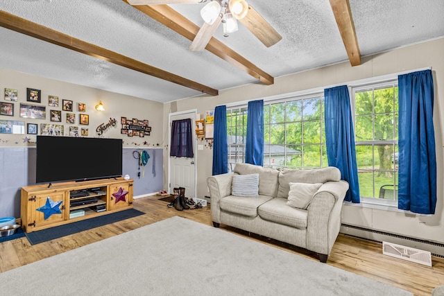 1650 Clouse Rd, Macomb, MO 65702 - living area with a textured ceiling, beamed ceiling, wood finished floors, ceiling fan, and a baseboard heating unit