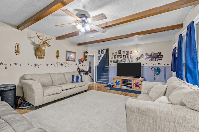 1650 Clouse Rd, Macomb, MO 65702 - living area featuring wood finished floors, beamed ceiling, a textured ceiling, stairs, and a ceiling fan