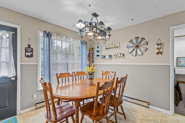 1650 Clouse Rd, Macomb, MO 65702 - dining room featuring a baseboard radiator, a chandelier, a wainscoted wall, a textured ceiling, and light tile patterned flooring