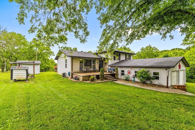 1650 Clouse Rd, Macomb, MO 65702 - back of property featuring an outbuilding, a deck, a lawn, and central AC