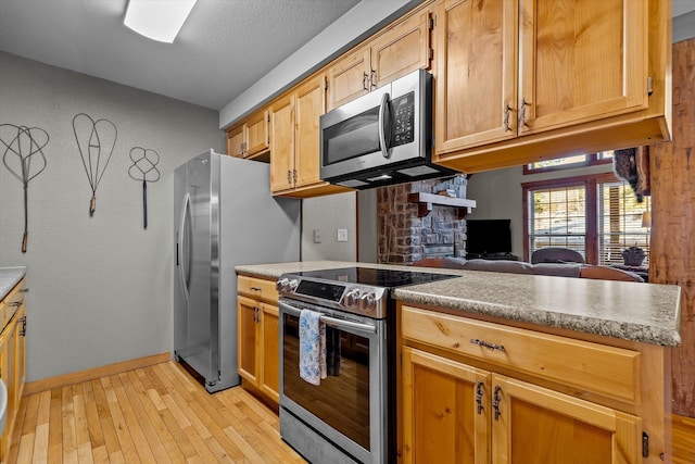 60 Mayberry Cir, Branson West, MO 65737 - kitchen featuring stainless steel appliances, light wood-type flooring, baseboards, and a peninsula