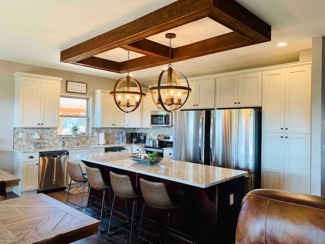 240 Chateau Cove Dr, Branson, MO 65616 - kitchen featuring appliances with stainless steel finishes, a chandelier, white cabinets, a kitchen island, and backsplash