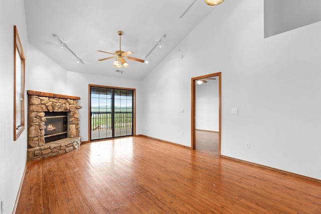160 Village Trl, Indian Point, MO 65616 - unfurnished living room with rail lighting, hardwood / wood-style flooring, a ceiling fan, a fireplace, and high vaulted ceiling