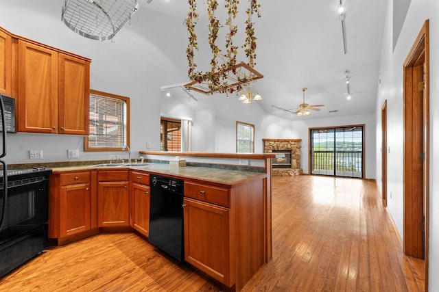160 Village Trl, Indian Point, MO 65616 - kitchen featuring black appliances, a sink, a peninsula, light wood-type flooring, and a stone fireplace