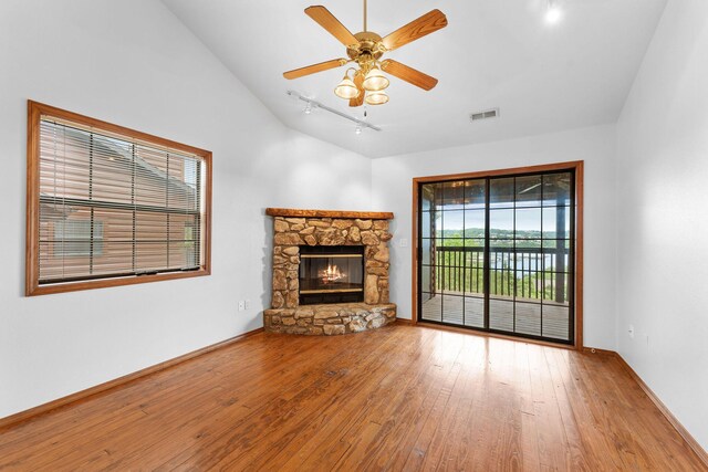 160 Village Trl, Indian Point, MO 65616 - unfurnished living room featuring hardwood / wood-style flooring, track lighting, vaulted ceiling, a fireplace, and a ceiling fan