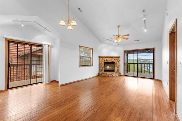 160 Village Trl, Indian Point, MO 65616 - unfurnished living room featuring rail lighting, wood-type flooring, lofted ceiling, a ceiling fan, and a stone fireplace