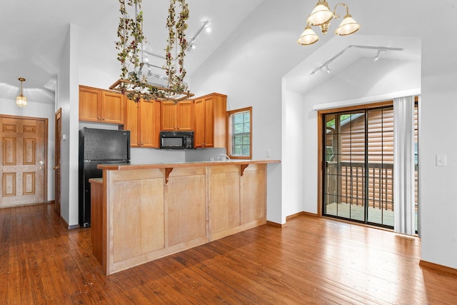160 Village Trl, Indian Point, MO 65616 - kitchen with black appliances, rail lighting, a chandelier, a peninsula, and dark wood-style flooring