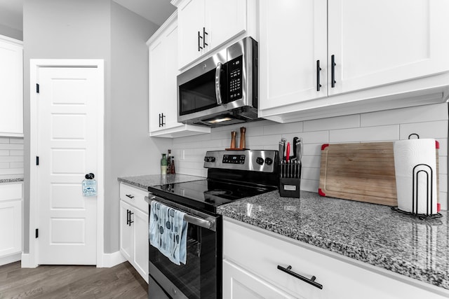 1682 Vicksburg Psge, Republic, MO 65738 - kitchen featuring appliances with stainless steel finishes, dark wood-style flooring, dark stone counters, and decorative backsplash