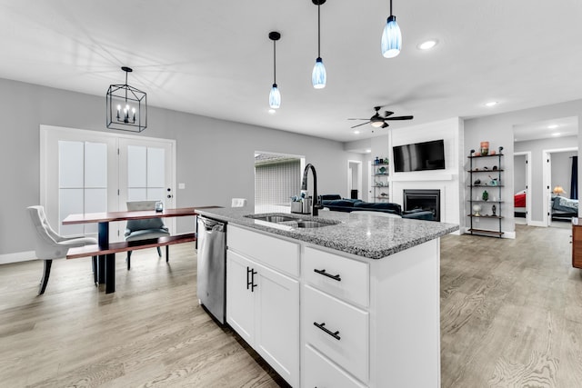1682 Vicksburg Psge, Republic, MO 65738 - kitchen featuring a sink, stainless steel dishwasher, a fireplace, light stone countertops, and light wood-style floors