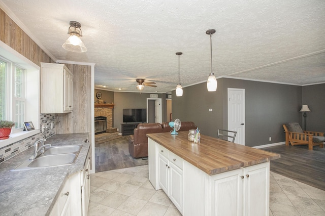 4857 S 101st Rd, Bolivar, MO 65613 - kitchen with a sink, a stone fireplace, wooden counters, a textured ceiling, and ornamental molding