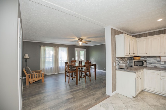 4857 S 101st Rd, Bolivar, MO 65613 - kitchen with stainless steel microwave, ornamental molding, a textured ceiling, a ceiling fan, and backsplash