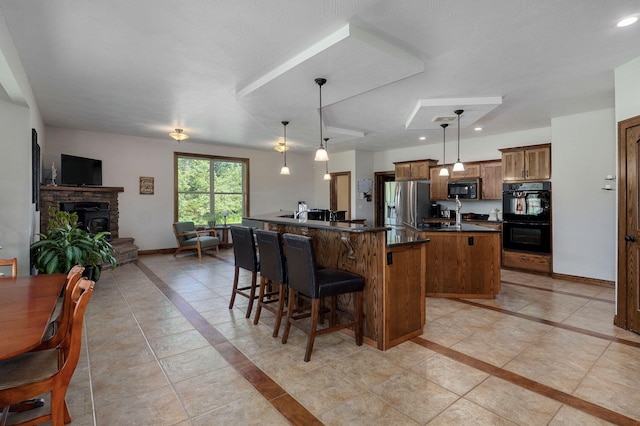 7519 W Farm Rd Unit 194, Republic, MO 65738 - kitchen with black appliances, inlaid floor details, a center island, dark countertops, and brown cabinets