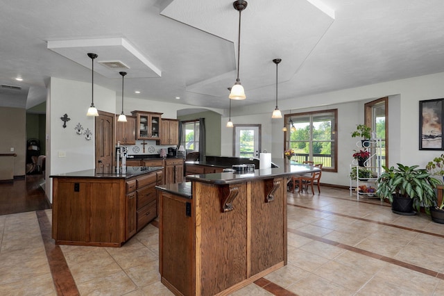 7519 W Farm Rd Unit 194, Republic, MO 65738 - kitchen with dark countertops, a kitchen bar, glass insert cabinets, inlaid floor details, and recessed lighting